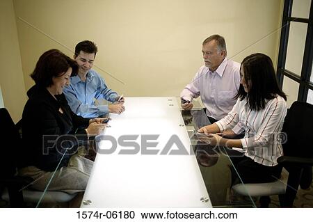 Four business executives in a conference room View Large Photo Image Stock Image - Four business executives in a conference room. Fotosearch