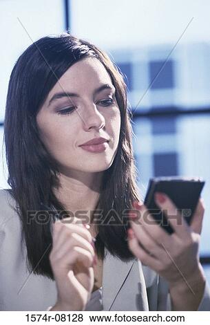 Stock Photo - Front profile of a businesswoman using a hand held device. Fotosearch