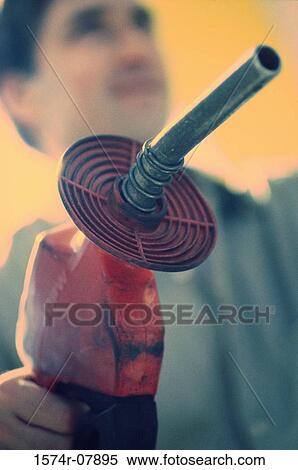 Stock Photography - Gas station attendant holding a gas pump nozzle. Fotosearch