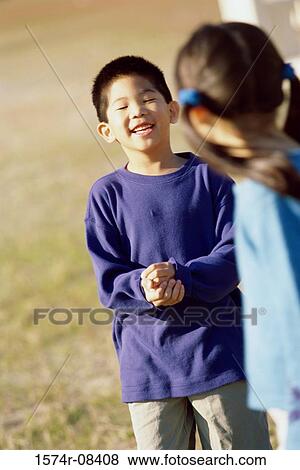 Stock Photo - Girl and a boy playing on a lawn. Fotosearch