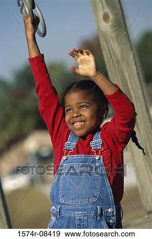 Girl hanging on a ring at the playground View Large Photo Image Stock Photo - Girl hanging on a ring at the playground. Fotosearch