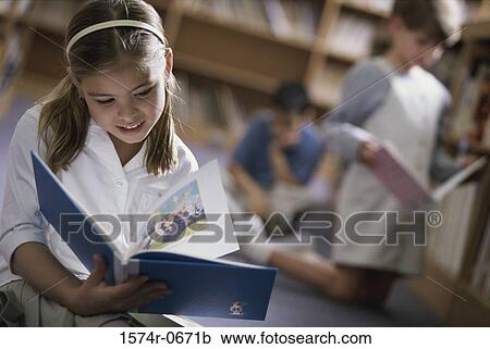 Girl holding a book in a classroom View Large Photo Image Stock Image - Girl holding a book in a classroom. Fotosearch