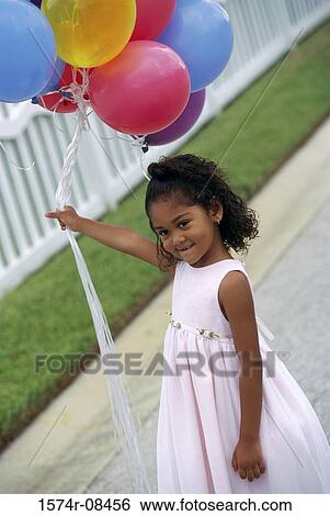 Stock Photograph - Girl holding balloons. Fotosearch