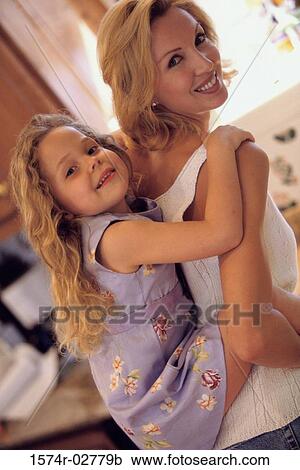 Stock Image - Girl riding piggyback on her mother. Fotosearch