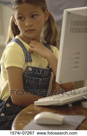 Girl sitting in front of a computer monitor View Large Photo Image Stock Photo - Girl sitting in front of a computer monitor. Fotosearch
