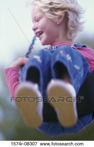 Girl sitting on a swing View Large Photo Image Stock Photo - Girl sitting on a swing. Fotosearch