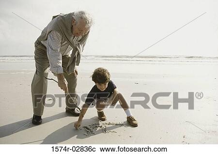 Grandfather playing with his grandson on the beach View Large Photo Image Stock Image - Grandfather playing with his grandson on the beach. Fotosearch