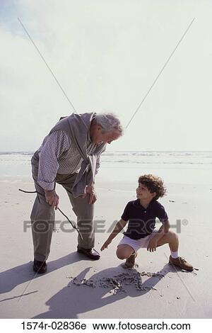 Grandfather playing with his grandson on the beach View Large Photo Image Stock Image - Grandfather playing with his grandson on the beach. Fotosearch