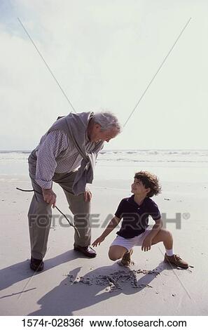Grandfather playing with his grandson on the beach View Large Photo Image Stock Image - Grandfather playing with his grandson on the beach. Fotosearch