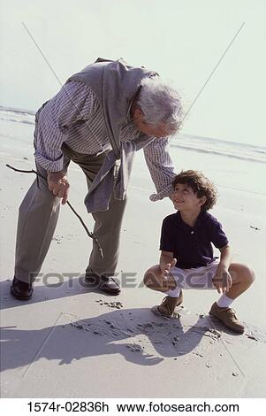 Grandfather playing with his grandson on the beach View Large Photo Image Stock Image - Grandfather playing with his grandson on the beach. Fotosearch