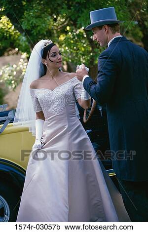 Stock Image - Groom holding his bride's hand. Fotosearch