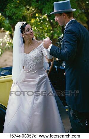Stock Image - Groom holding his bride's hand. Fotosearch