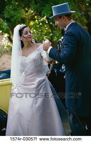 Stock Image - Groom holding his bride's hand. Fotosearch