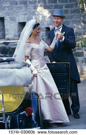 Stock Image - Groom holding his bride's hand. Fotosearch