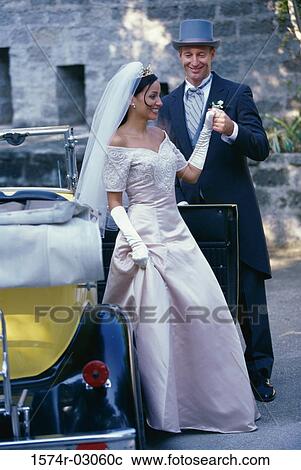 Stock Image - Groom holding his bride's hand. Fotosearch