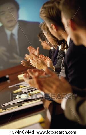 Stock Image - Group of business executives applauding at a meeting. Fotosearch