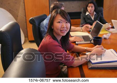 Stock Photo - Group of business executives sitting in a conference room. Fotosearch