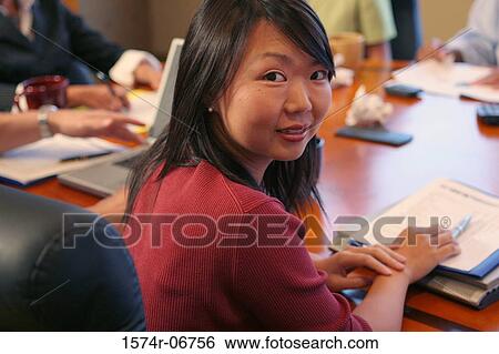 Stock Photograph - Group of business executives sitting in a conference room. Fotosearch