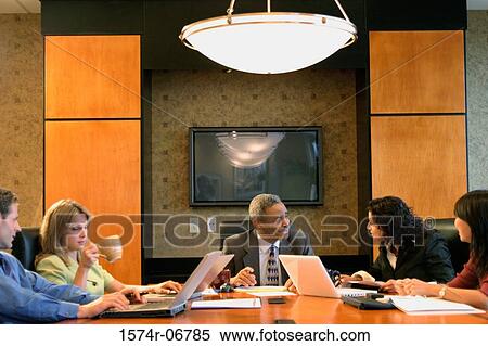 Stock Photography - Group of business executives sitting in a conference room. Fotosearch