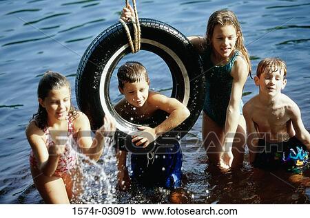 Group of children playing on a tire swing View Large Photo Image Stock Image - Group of children playing on a tire swing. Fotosearch