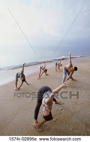 Group of people performing yoga on the beach View Large Photo Image Stock Image - Group of people performing yoga on the beach. Fotosearch