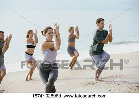 Group of people performing yoga on the beach View Large Photo Image Stock Image - Group of people performing yoga on the beach. Fotosearch