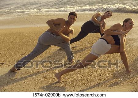 Group of people performing yoga on the beach View Large Photo Image Stock Image - Group of people performing yoga on the beach. Fotosearch