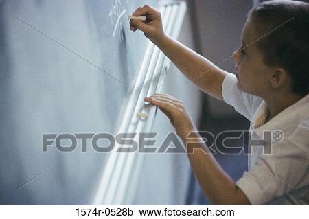 High angle view of a boy writing on a blackboard View Large Photo Image Stock Image - High angle view of a boy writing on a blackboard. Fotosearch