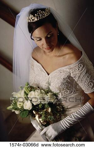 Stock Image - High angle view of a bride holding a bouquet of flowers. Fotosearch