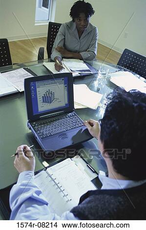 High angle view of a businessman and a businesswoman sitting in a conference room View Large Photo Image Picture - High angle view of a businessman and a businesswoman sitting in a conference room. Fotosearch