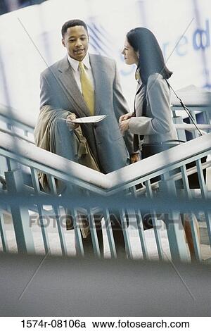 Stock Image - High angle view of a businessman and a businesswoman talking. Fotosearch