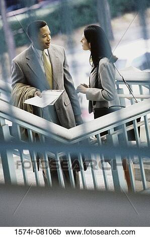 Stock Image - High angle view of a businessman and a businesswoman face to face. Fotosearch