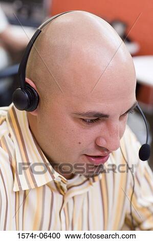 High angle view of a businessman wearing a headset in an office View Large Photo Image Stock Image - High angle view of a businessman wearing a headset in an office. Fotosearch