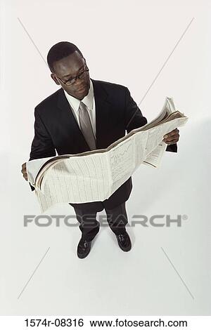 Stock Photograph - High angle view of a businessman reading a newspaper. Fotosearch