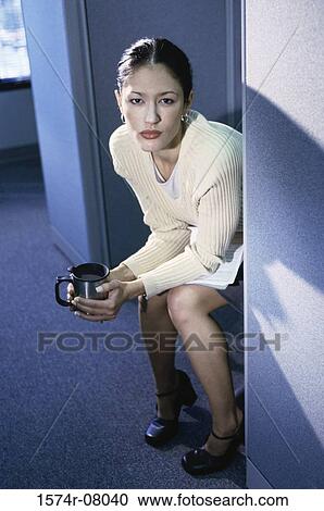 Stock Image - High angle view of a businesswoman holding a coffee mug. Fotosearch