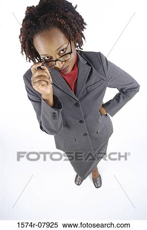 Stock Photography - High angle view of a businesswoman adjusting her eyeglasses. Fotosearch