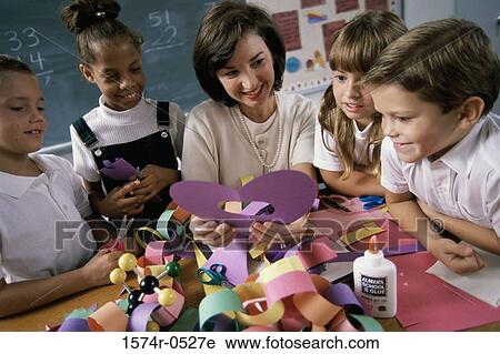 High angle view of a female teacher teaching her students arts and crafts View Large Photo Image Stock Image - High angle view of a female teacher teaching her students arts and crafts. Fotosearch