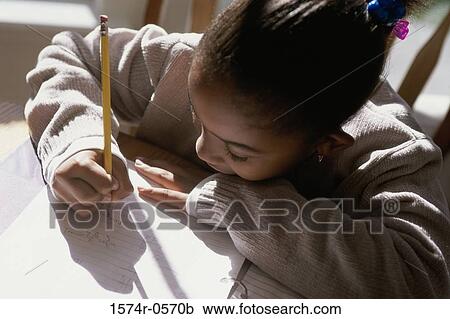 High angle view of a girl writing on paper with a pencil View Large Photo Image Stock Image - High angle view of a girl writing on paper with a pencil. Fotosearch