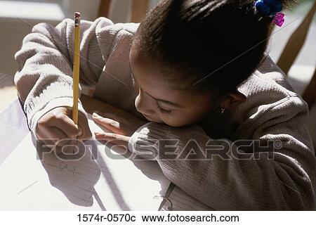High angle view of a girl writing on paper with a pencil View Large Photo Image Stock Image - High angle view of a girl writing on paper with a pencil. Fotosearch