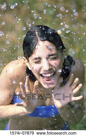 Stock Photo - High angle view of a teenage girl playing in the rain. Fotosearch