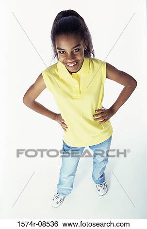 Stock Photograph - High angle view of a teenage girl standing with her hands on her hips. Fotosearch