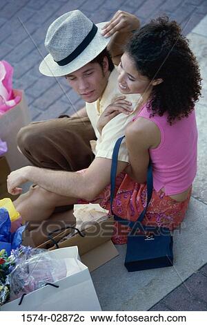 High angle view of a young couple sitting on the sidewalk with shopping bags View Large Photo Image Stock Image - High angle view of a young couple sitting on the sidewalk with shopping bags. Fotosearch
