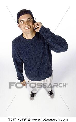 High angle view of a young man talking on a mobile phone View Large Photo Image Stock Image - High angle view of a young man talking on a mobile phone. Fotosearch