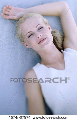 High angle view of a young woman lying on the beach View Large Photo Image Picture - High angle view of a young woman lying on the beach. Fotosearch