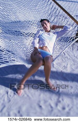 Stock Image - High angle view of a young woman lying in a hammock. Fotosearch
