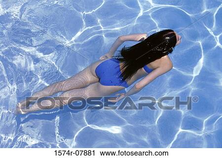 High angle view of a young woman swimming in a swimming pool View Large Photo Image Stock Image - High angle view of a young woman swimming in a swimming pool. Fotosearch