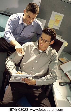Stock Image - High angle view of two businessmen in an office. Fotosearch