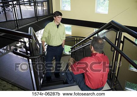 Stock Image - High angle view of two businessmen on a staircase. Fotosearch