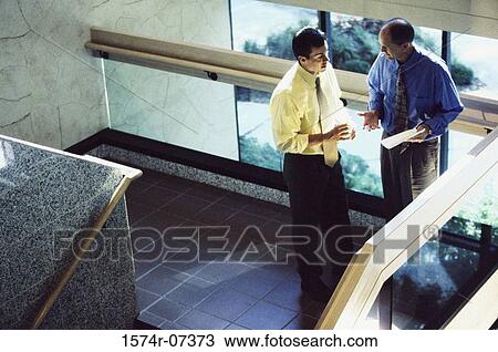 High angle view of two businessmen discussing a report View Large Photo Image Stock Image - High angle view of two businessmen discussing a report. Fotosearch