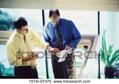 High angle view of two businessmen discussing a report View Large Photo Image Stock Photography - High angle view of two businessmen discussing a report. Fotosearch